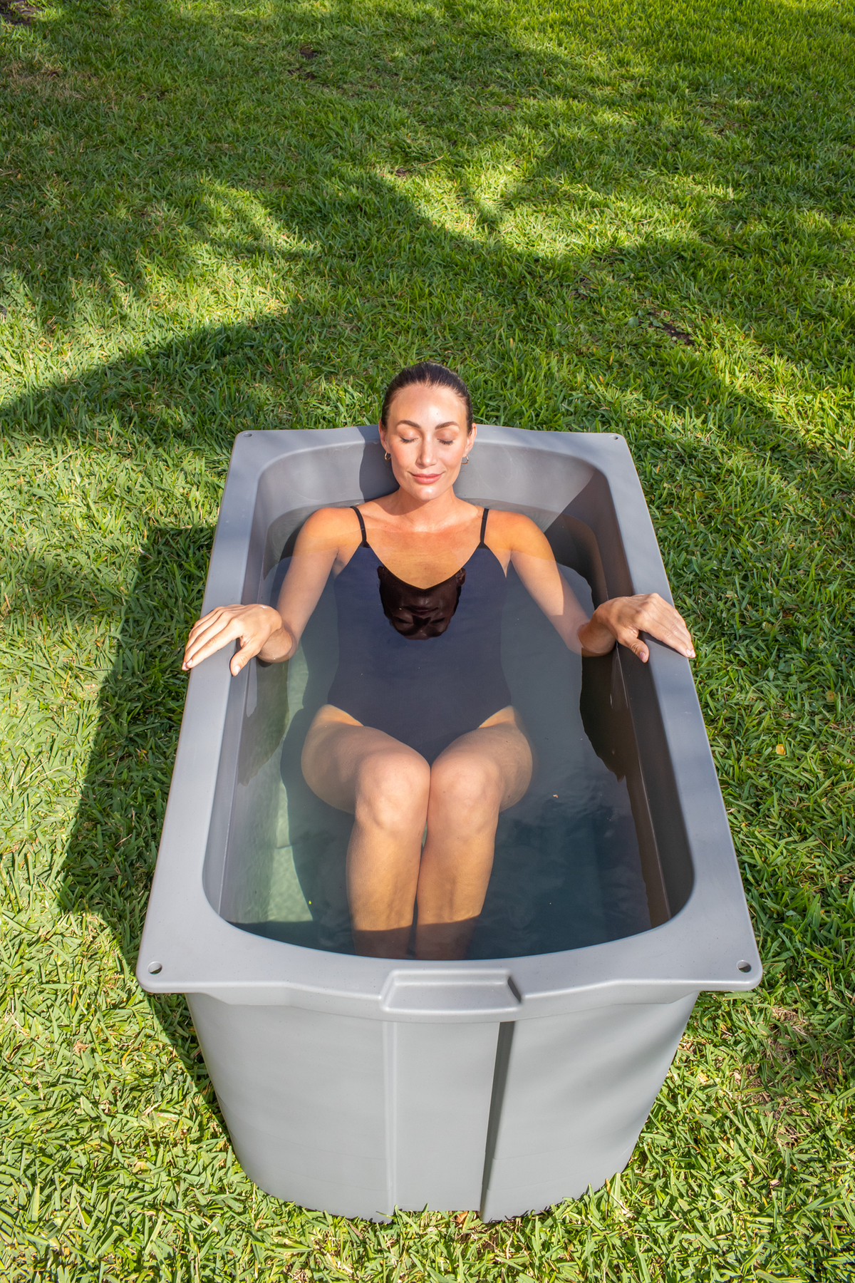 Woman using a Frozin 400 Grey Granite cold plunge outdoors